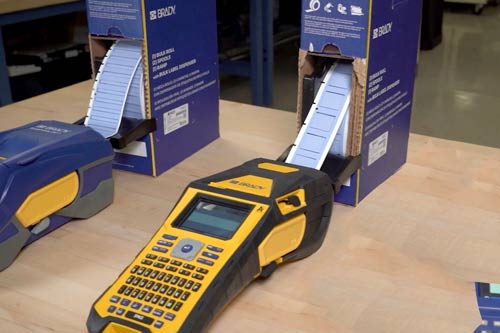 En stor eske med etiketter mates kontinuerlig inn i en M610 etikettskriver.