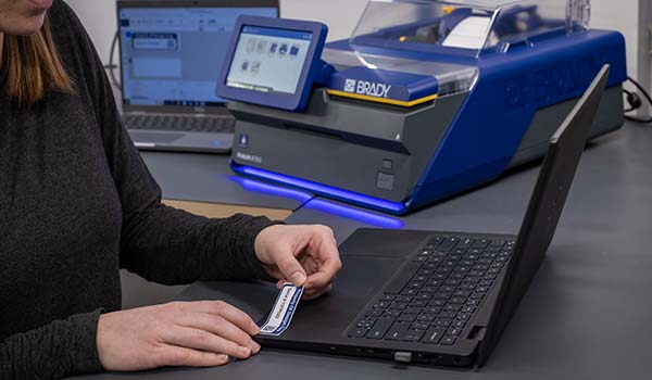 En medarbeider setter inventarmerking på en bærbar datamaskin.