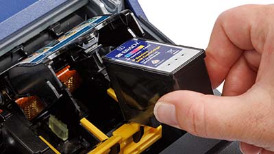 En person som legger i en blekkpatron.