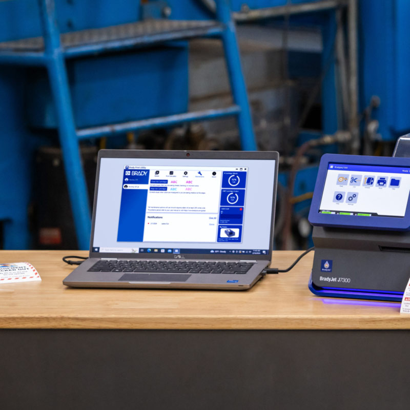 En bærbar datamaskin som er koblet til en J7300, viser en skjerm fra Brady Workstation.