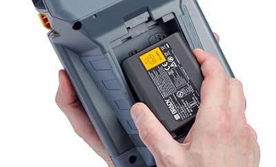 En person som installerer et høykapasitetsbatteri i en Brady M510-skriver